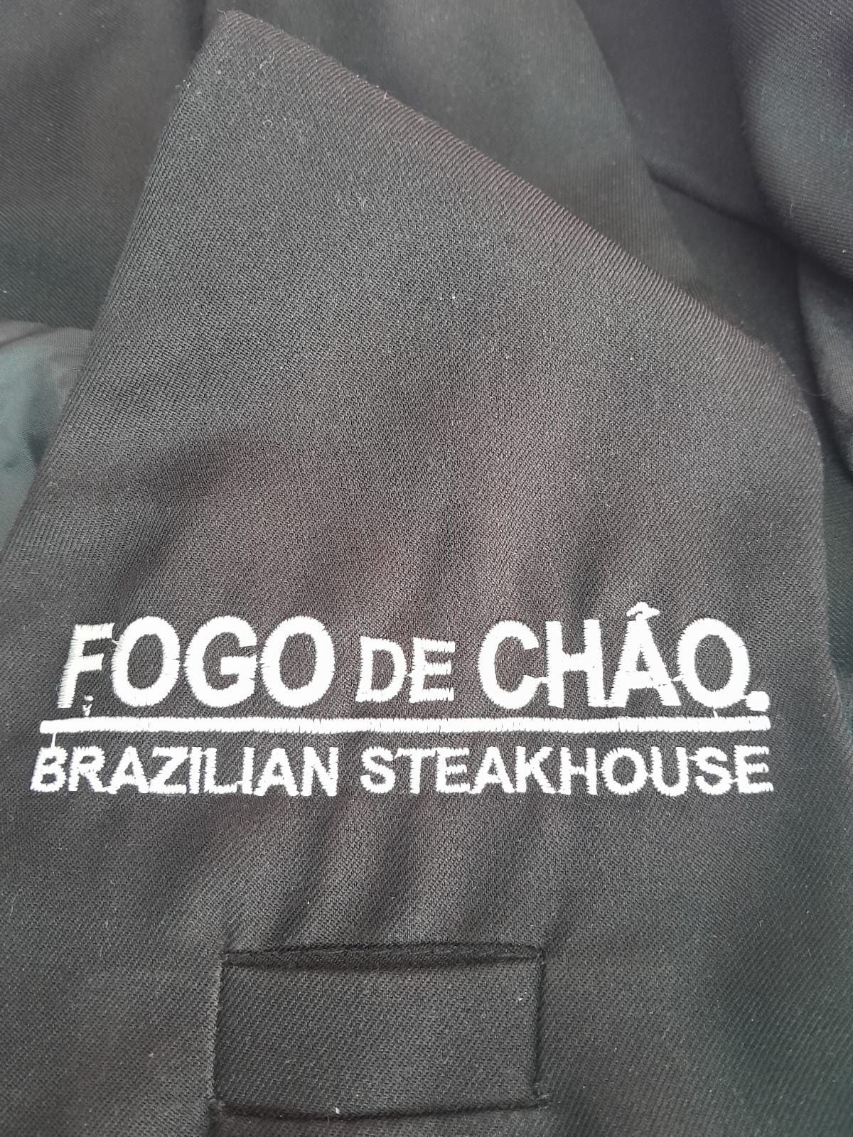 Bordado Fogo de Chão Brazilian Steakhouse sobre uniforme negro